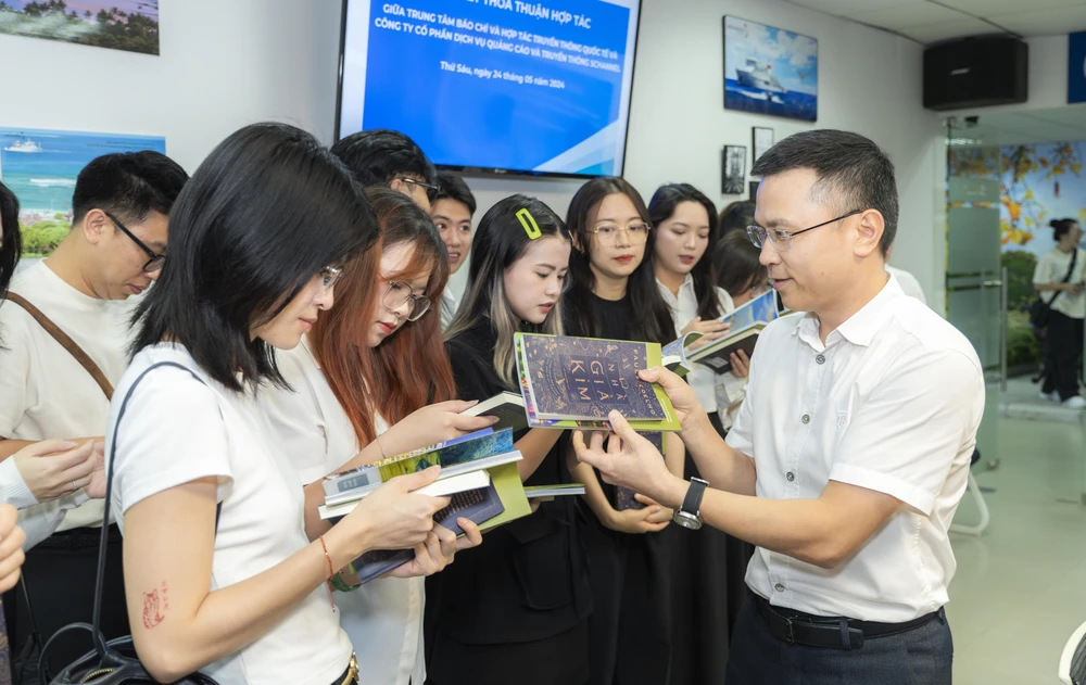 Cục trưởng Cục Thông tin Đối ngoại Phạm Anh Tuấn với các bạn trẻ thuộc Schannel. (Ảnh: CTV/Vietnam+)