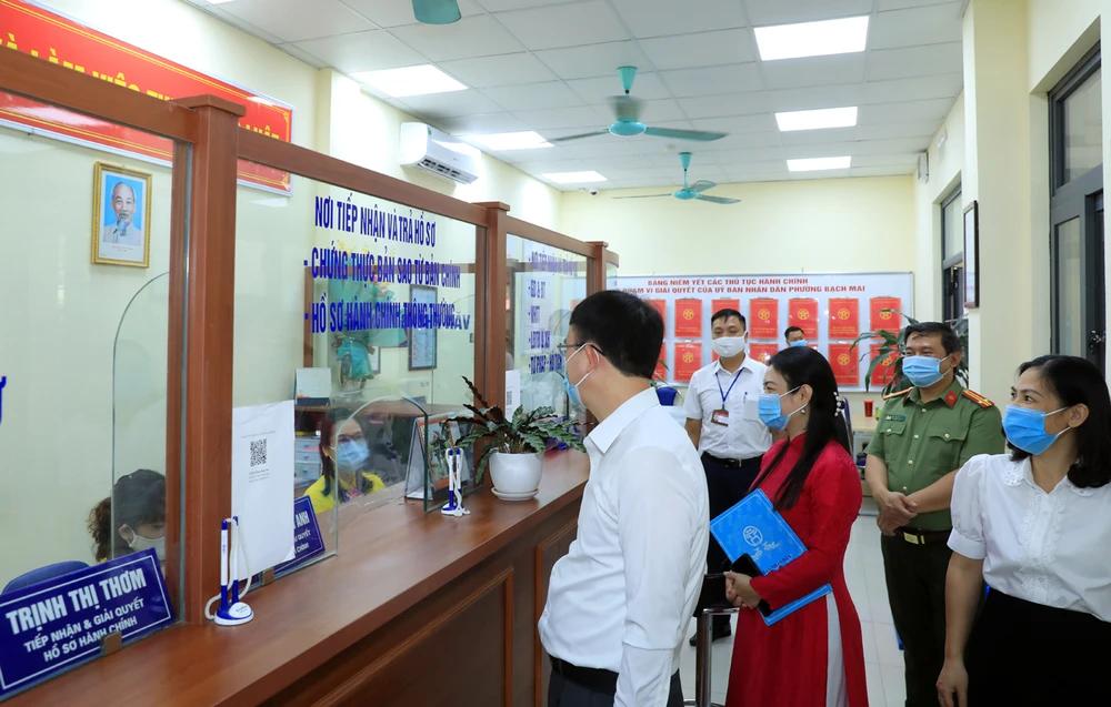 Chủ tịch Ủy ban Nhân dân quận Hai Bà Trưng kiểm tra tại bộ phận một cửa phường Bạch Mai. (Ảnh: Xuân Quảng/Vietnam+)