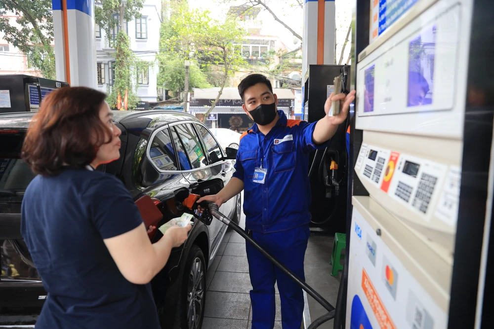 Nhân viên Petrolimex bán xăng cho khách hàng. (Ảnh: Đức Duy/Vietnam+)