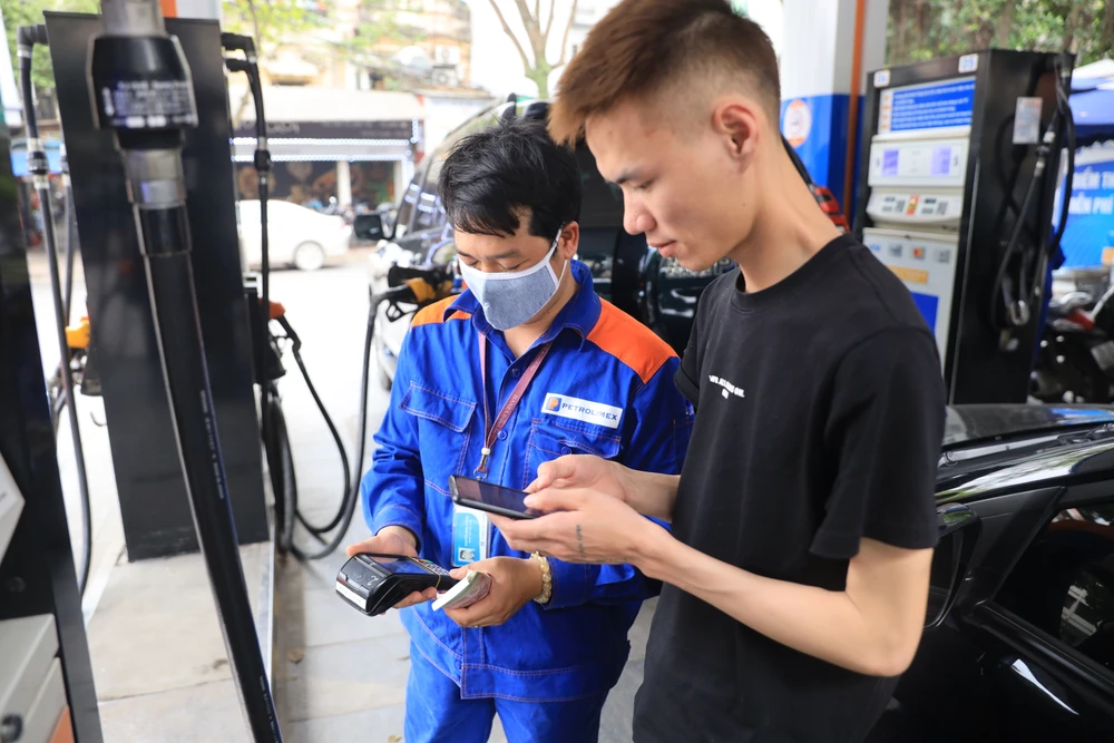 Nhân viên Petrolimex in hóa đơn mua xăng cho khách hàng. (Ảnh: Đức Duy/Vietnam+)