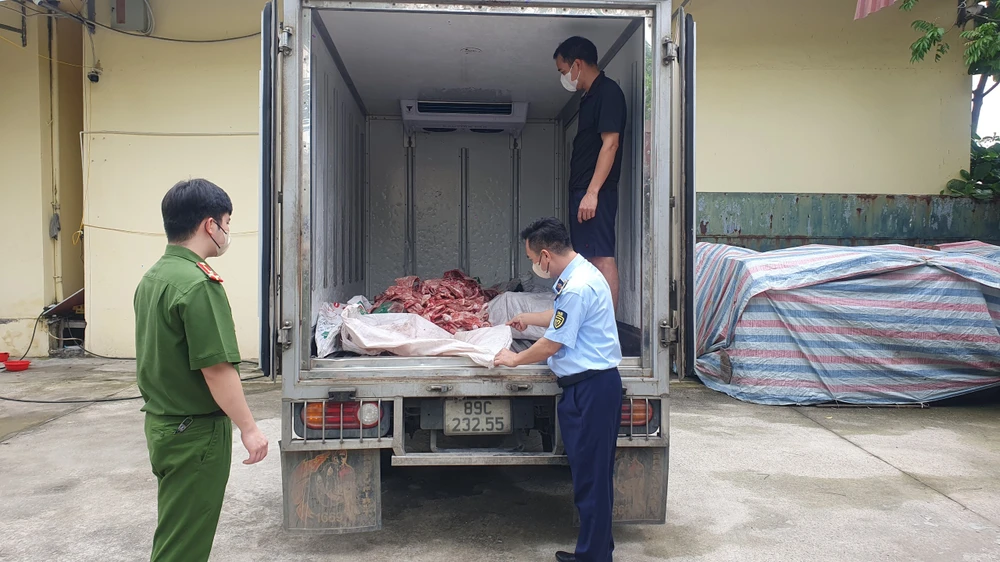 Lực lượng chức năng kiểm tra xe ôtô chở xương và lòng lợn không rõ nguồn gốc. (Ảnh: PV/Vietnam+)