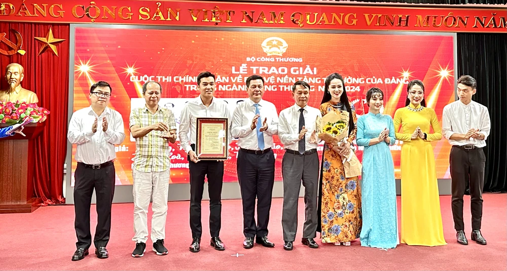 Bộ trưởng Nguyễn Hồng Diên cùng Phó Chủ tịch thường trực Hội Nhà báo Việt Nam Nguyễn Đức Lợi trao giải đặc biệt cho nhóm tác giả Báo Công Thương Cuộc thi chính luận về bảo vệ nền tảng tư tưởng của Đảng ngành Công Thương. (Ảnh: Đức Duy/Vietnam+)