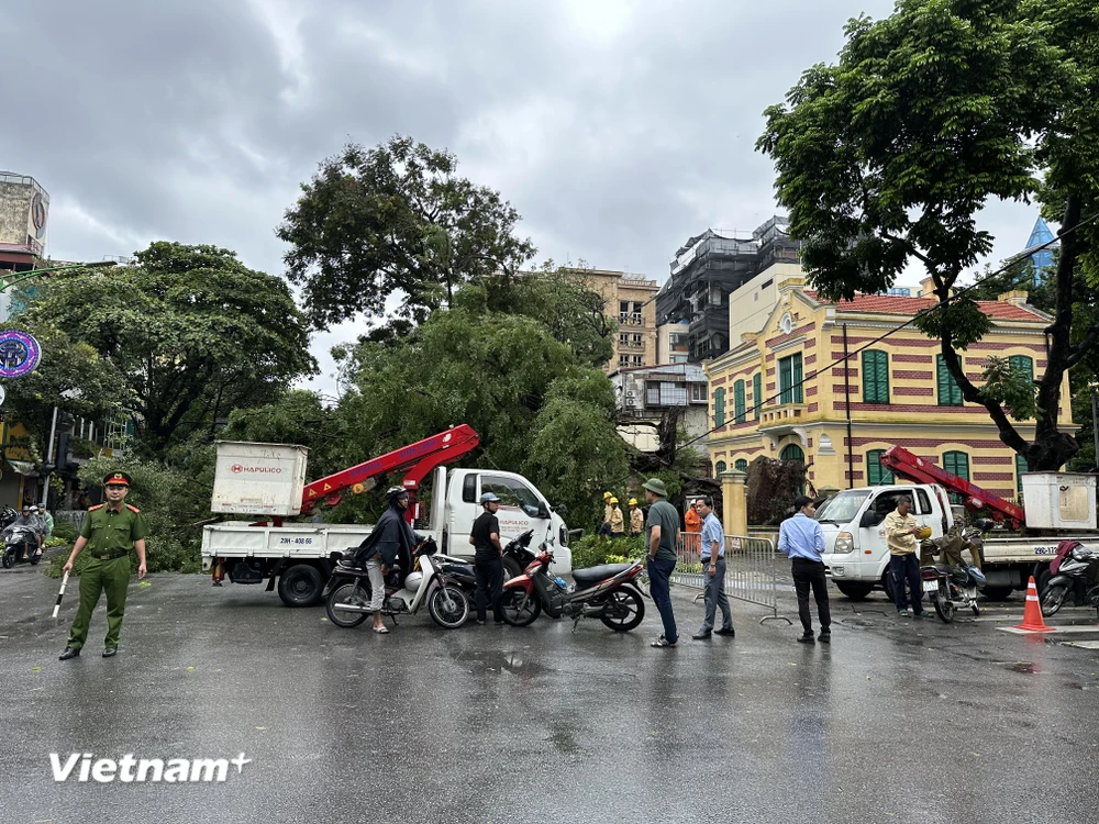 Các lực lượng chúc năng của Hà Nội tiến hành phân luồng, đảm bảo an toàn giao thông sau mưa bão. (Ảnh: Xuân Quảng/Vietnam+)