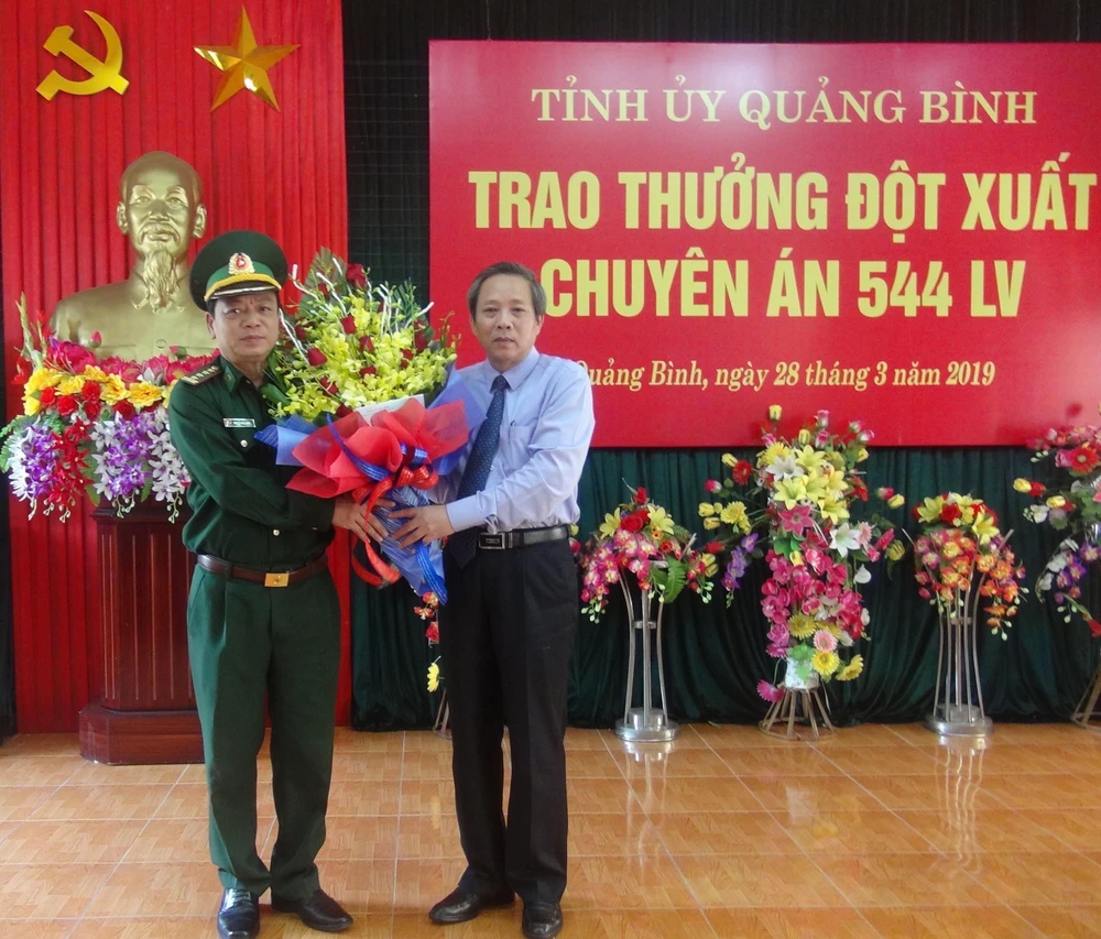 Bí thư Tỉnh ủy Quảng Bình Hoàng Đăng Quang tặng hoa cho Đại diện Bộ chỉ huy Bộ đội biên phòng Quảng Bình sau chuyên án 544LV thành công. (Ảnh: Đức Thọ/TTXVN) 