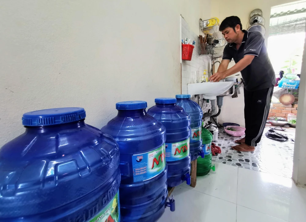 Trung bình mỗi tháng, người dân sống tại hẻm 111, đường Võ Văn Kiệt phải chi thêm khoảng 200 nghìn đồng để mua nước lọc dùng cho ăn uống. (Ảnh: Thanh Liêm/TTXVN) 