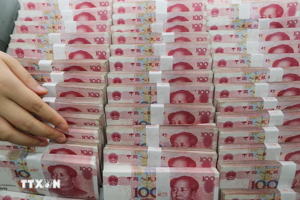 Đồng tiền mệnh giá 100 nhân dân tệ tại ngân hàng ở tỉnh Giang Tô, Trung Quốc. (Ảnh: AFP/TTXVN)