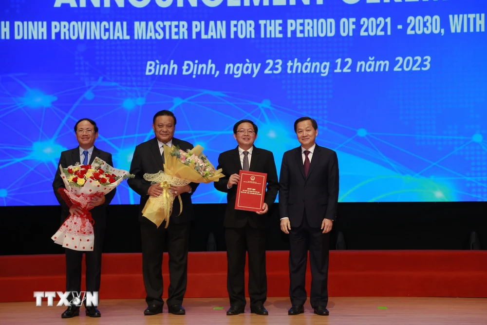 Trao chứng nhận quyết định phê duyệt Quy hoạch tỉnh Bình Định thời kỳ 2021-2030, tầm nhìn đến 2050. (Ảnh: Sỹ Thắng/TTXVN)