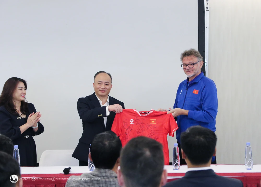 Huấn luyện viên trưởng Philippe Troussier thay mặt đội tuyển tặng Đại sứ quán Việt Nam tại Qatar áo thi đấu có chữ ký của các thành viên đội tuyển. (Nguồn: VFF)