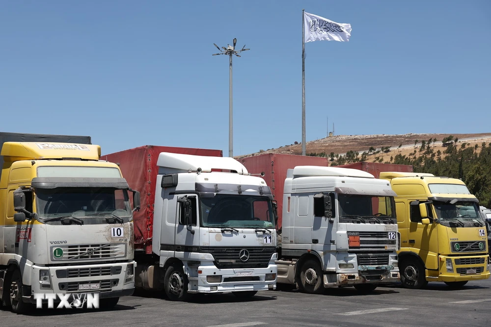 Đoàn xe chở hàng cứu trợ nhân đạo sau khi qua cửa khẩu biên giới Bab al-Hawa ở Syria, ngày 10/7/2023. (Ảnh: AFP/TTXVN)