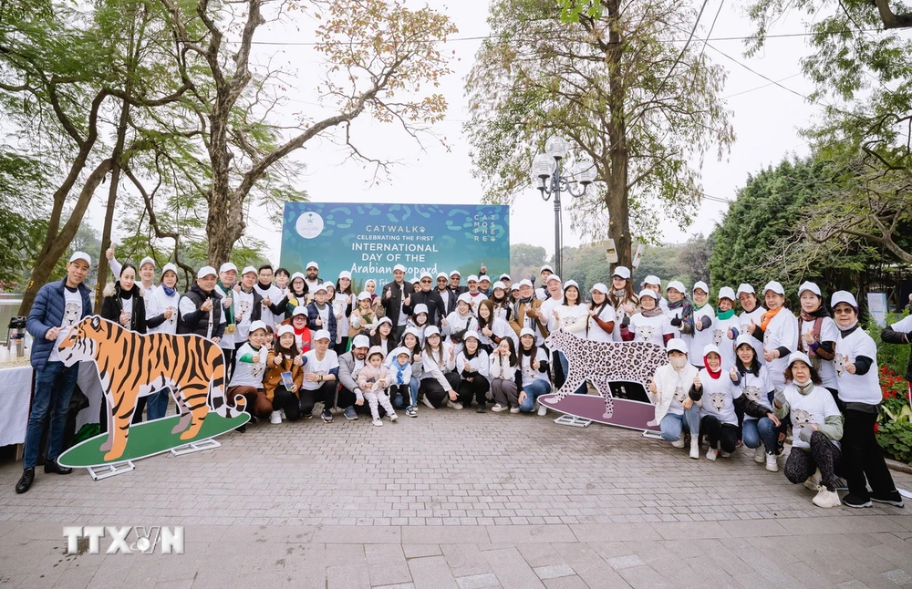 Các nhà ngoại giao quốc tế và gia đình tham gia chương trình đi bộ bên Hồ Hoàn Kiếm kêu gọi bảo tồn thú họ Mèo. (Ảnh: TTXVN phát)