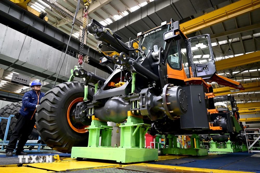 Công nhân làm việc trên dây chuyền sản xuất máy kéo Develon ở Yên Đài, tỉnh Sơn Đông (Trung Quốc) ngày 17/1/2024. (Ảnh: THX/TTXVN)