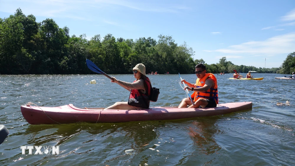 Du khách quốc tế chèo thuyền Kayak trên sông Cửa Cạn, thành phố Phú Quốc (Kiên Giang). (Ảnh: Lê Huy Hải/TTXVN)