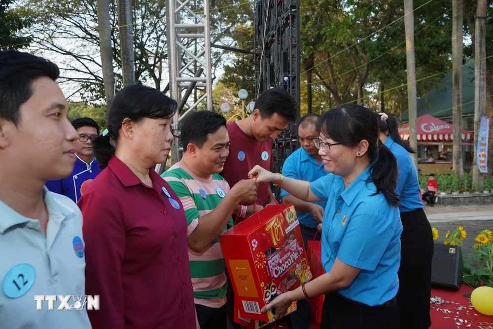 Bà Trần Thị Diệu Thúy, Chủ tịch Liên đoàn Lao động Thành phố Hồ Chí Minh, tăng quà cho công nhân lao động. (Ảnh: Thanh Vũ/TTXVN)