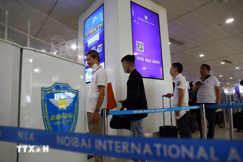 Hành khách xếp hàng vào làm thủ tục an ninh tại nhà ga T1 Sân bay Nội Bài. (Ảnh: Huy Hùng/TTXVN)
