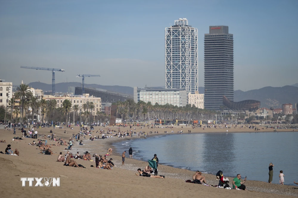 Người dân tắm mát trên bãi biển ở Barcelona, Tây Ban Nha. (Ảnh: AFP/TTXVN)