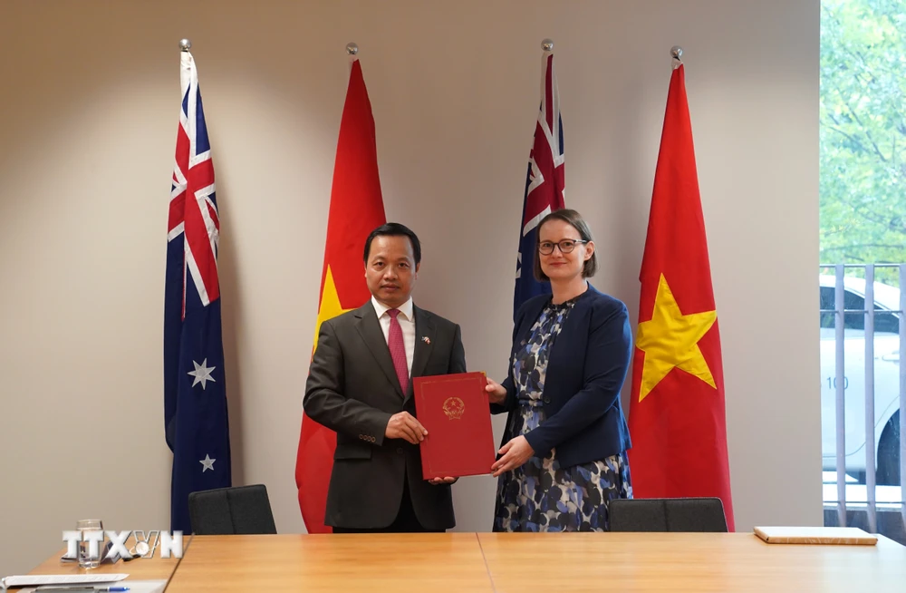 Thứ trưởng Bộ Tư pháp Việt Nam Trần Tiến Dũng và Thứ trưởng Bộ Tư pháp Australia Tara Inverarity trao Ý định thư hợp tác giữa hai Bộ. (Ảnh: Lê Đạt/TTXVN)