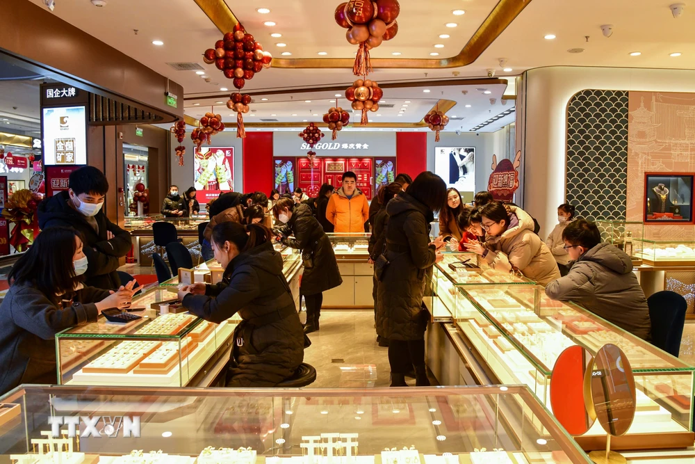 Khách hàng chọn mua trang sức tại tiệm vàng ở tỉnh Sơn Đông, Trung Quốc. (Ảnh: THX/TTXVN)