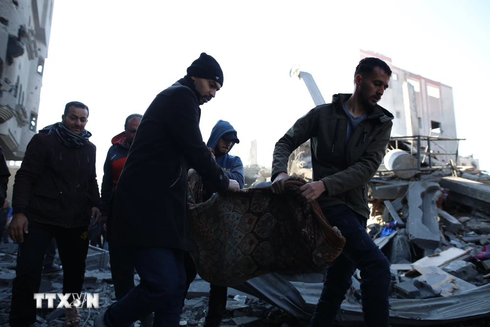 Cứu trợ các nạn nhân tại hiện trường đổ nát sau vụ không kích của Israel xuống trại tị nạn Nuseirat ở Dải Gaza, ngày 20/3/2024. (Ảnh: THX/TTXVN)