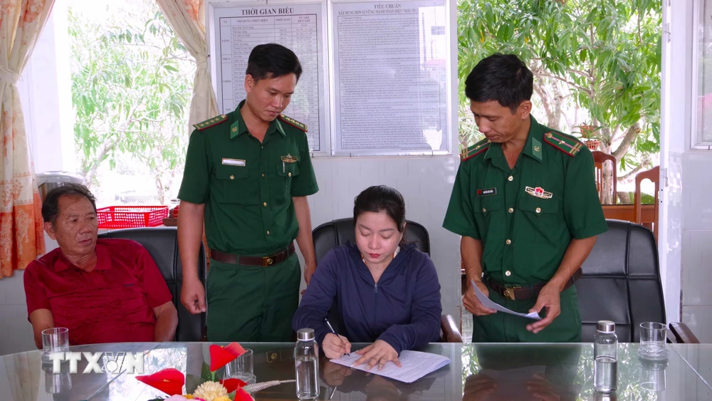 Bà Trần Hồng Diễm, chủ tàu cá CM 92114 TS, ký biên bản triển khai Quyết định của Chủ tịch Ủy ban Nhân dân tỉnh về việc xử phạt vi phạm hành chính đối với tàu vi phạm. (Ảnh: TTXVN phát)