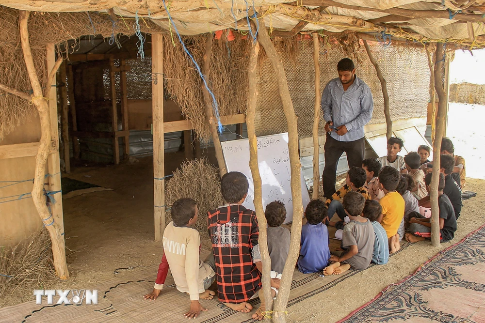 Giáo viên tình nguyện dạy học cho trẻ em tại một trại tị nạn ở tỉnh Hajjah, Yemen ngày 7/8/2023. (Ảnh: AFP/TTXVN)