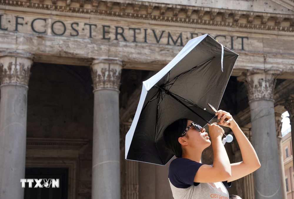 Du khách che ô khi di chuyển trong nắng gắt tại Rome, Italy ngày 18/7/2023. (Ảnh: THX/TTXVN)