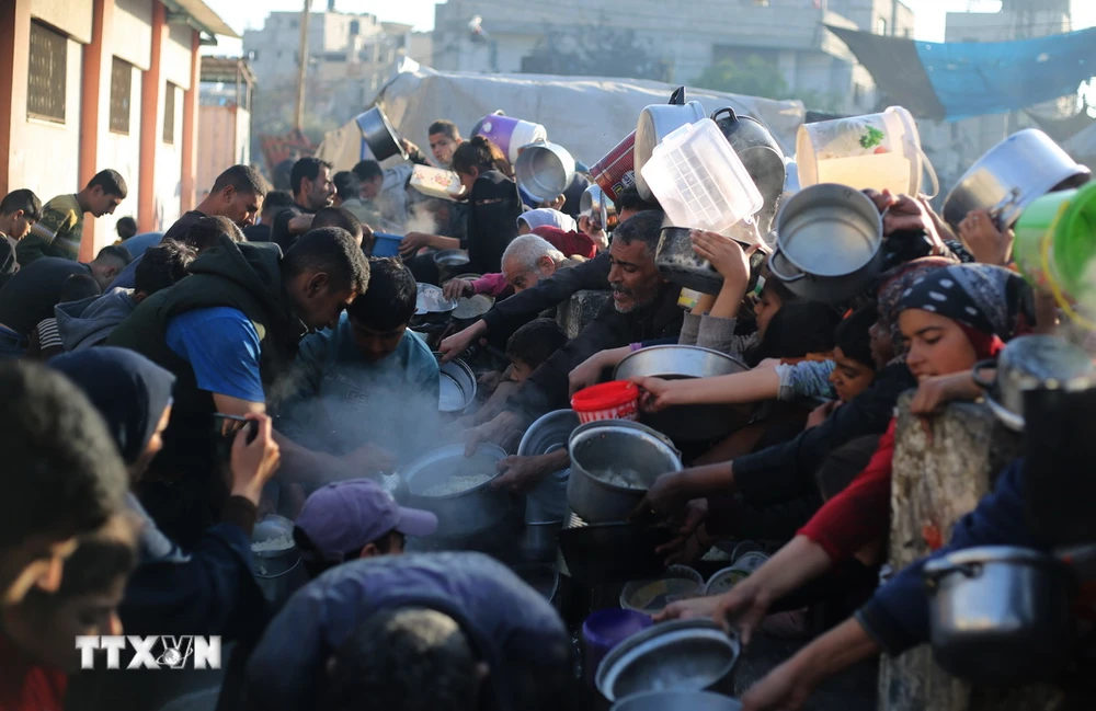Người dân xếp hàng chờ được phát thức ăn cứu trợ tại Rafah, Dải Gaza, ngày 14/3/2024. (Ảnh: THX/TTXVN)