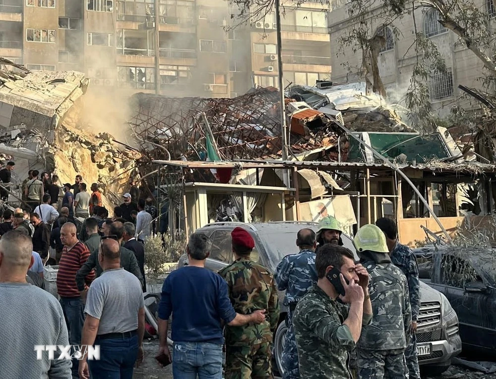 Lực lượng cứu hộ khẩn cấp làm nhiệm vụ tại hiện trường vụ oanh tạc khu vực gần Đại sứ quán Iran ở Damascus, Syria ngày 1/4/2024. (Ảnh: AFP/TTXVN) 
