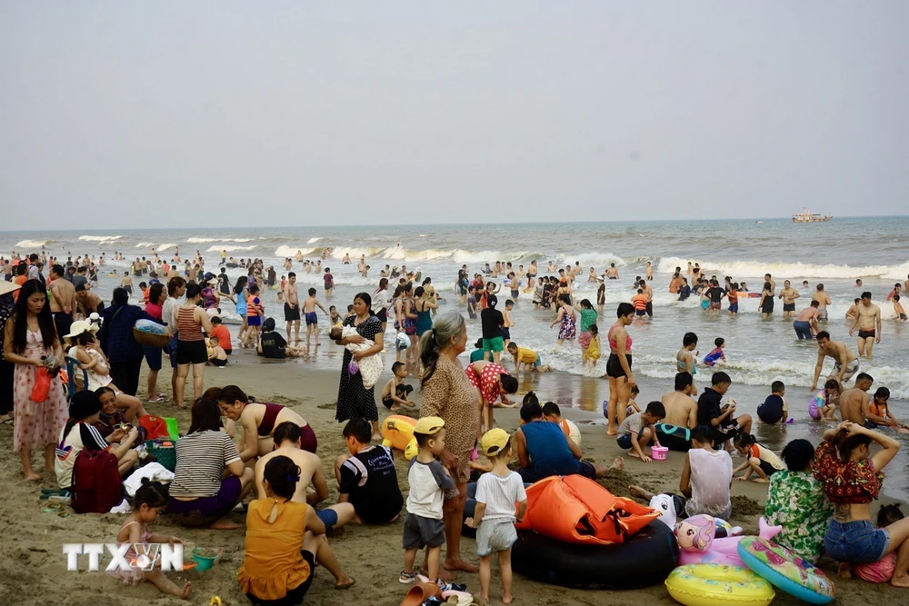 Du khách và người dân địa phương dồn về Bãi biển Sầm Sơn tránh nóng. (Ảnh: Hoa Mai/TTXVN)