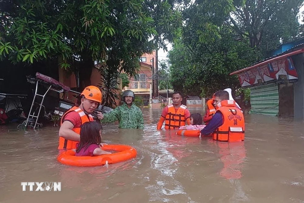 Lực lượng cứu hộ sơ tán người dân khỏi khu vực ngập lụt do bão Ewiniar tại tỉnh Quezon, Philippines ngày 26/5/2024. (Ảnh: AFP/TTXVN)