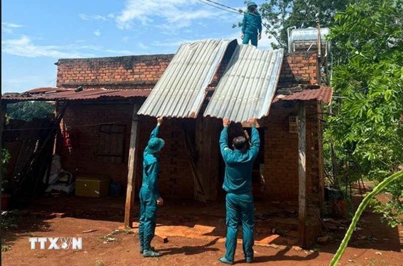 Lực lượng dân quân hỗ trợ người dân khắc phục hậu quả lốc xoáy. (Ảnh: TTXVN phát)