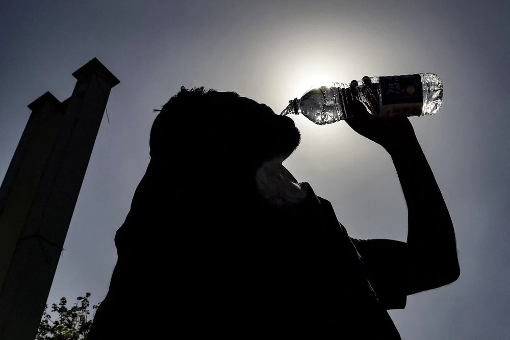 Người dân uống nước giải nhiệt trong ngày nắng nóng tại Jalandhar, Ấn Độ, ngày 11/6/2024. (Ảnh: AFP/TTXVN)