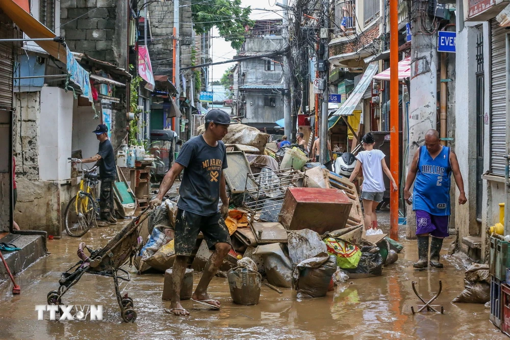 Người dân dọn dẹp sau mưa lũ tại Marikina, Philippines ngày 25/7/2024. (Nguồn: THX/TTXVN)