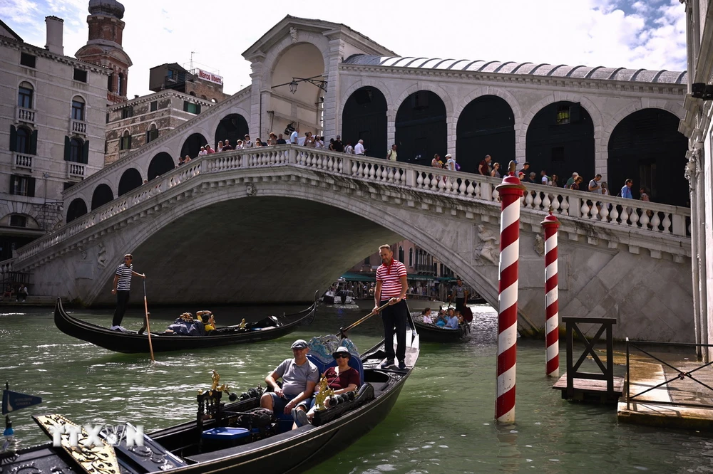 Khách du lịch đi thuyền gondola tại Venice, Italy. (Ảnh: AFP/TTXVN)