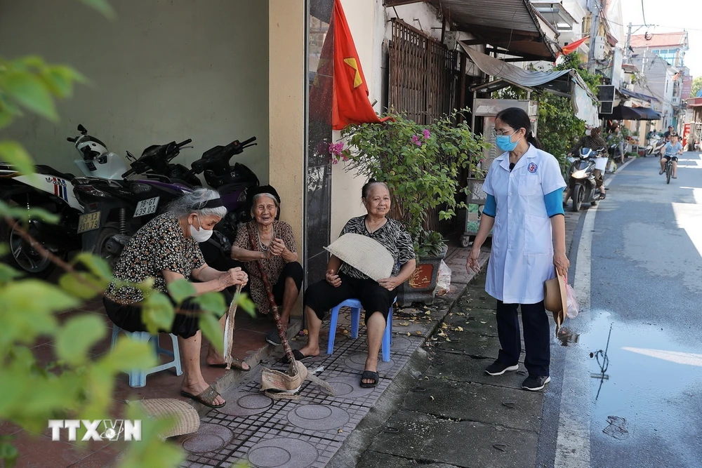 Nhân viên trạm y tế xã Thượng Mỗ (huyện Đan Phượng) tuyên truyền cho người dân về các biện pháp phòng dịch sốt xuất huyết. (Ảnh: Minh Quyết/TTXVN)