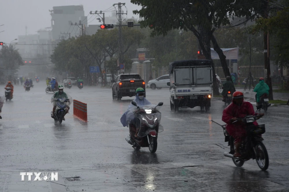 Phương tiện di chuyển gặp khó khăn do mưa lớn trên tuyến đường Núi Thành (quận Hải Châu). (Ảnh: Văn Dũng/TTXVN)