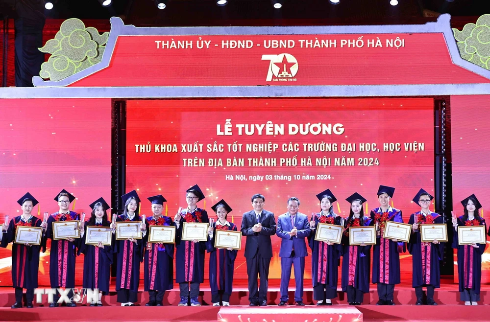 Ông Nguyễn Đắc Vinh, Ủy viên Trung ương Đảng, Chủ nhiệm Ủy ban Văn hóa, Giáo dục của Quốc hội và ông Nguyễn Văn Phong, Phó Bí thư Thành ủy Hà Nội trao Bằng khen của Chủ tịch Ủy ban Nhân dân Thành phố cho các thủ khoa xuất sắc tiêu biểu. (Ảnh: Minh Đức/TTXVN)