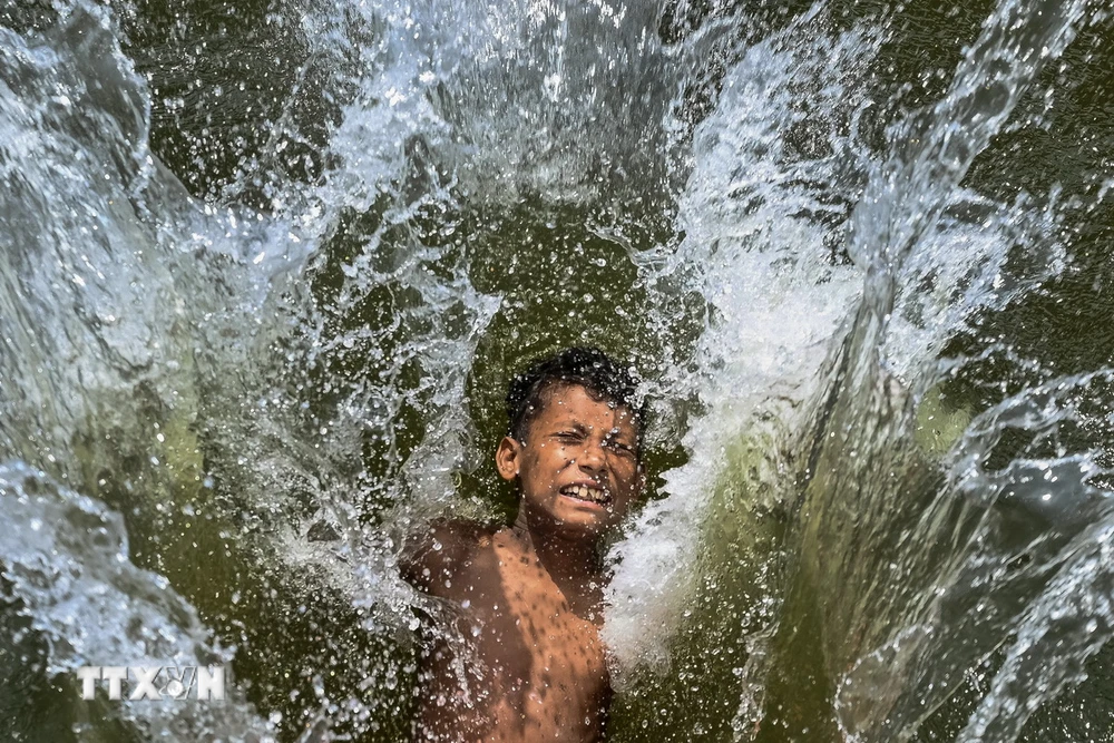 Trẻ em làm mát trong ngày nắng nóng gay gắt ở Dhaka, Bangladesh, ngày 29/4/2024. (Ảnh: AFP/TTXVN)