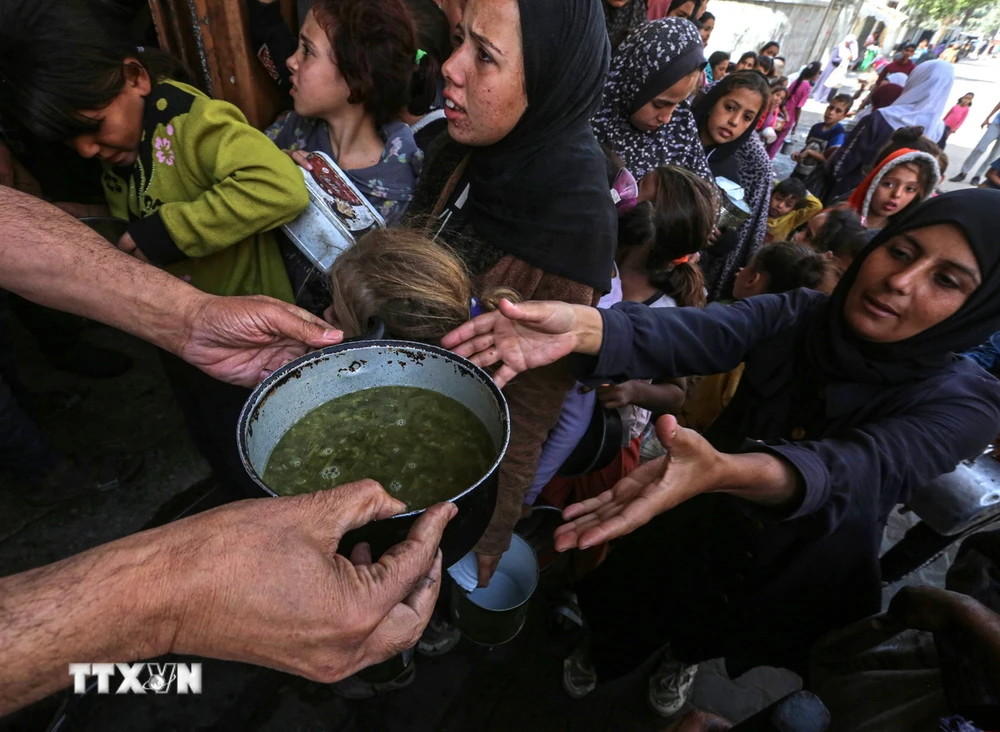 Người tị nạn Palestine nhận thức ăn cứu trợ tại thành phố Deir al-Balah, miền Trung Gaza ngày 25/10/2024. (Ảnh: THX/TTXVN)