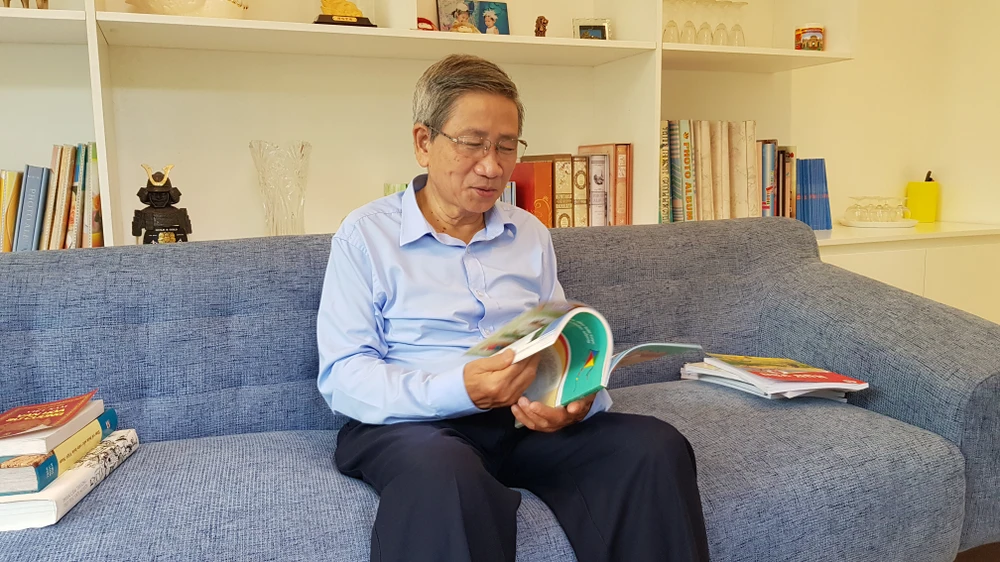 Giáo sư Nguyễn Minh Thuyết cầm trên tay bản mẫu của sách "Cánh diều" Tiếng Việt lớp 1, tập hai