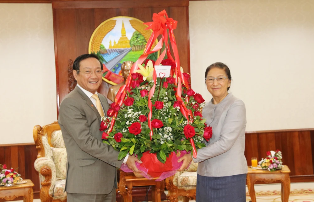 Đại sứ Nguyễn Bá Hùng (trái) chuyển hoa của Chủ tịch Quốc hội Việt Nam chúc mừng Chủ tịch Quốc hội Lào Pany Yathotou nhân dịp Bunpimay Lào. (Nguồn: Xuân Tú – Thu Phương/TTXVN)