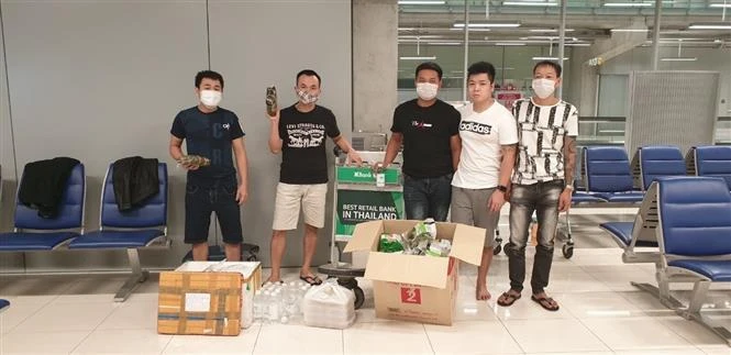 Nhóm công dân Việt Nam bị mắc kẹt tại sân bay Survanabhumi tiếp nhận thức ăn và đồ dùng thiết yếu do cán bộ Đại sứ quán chuyển đến. (Ảnh: TTXVN)