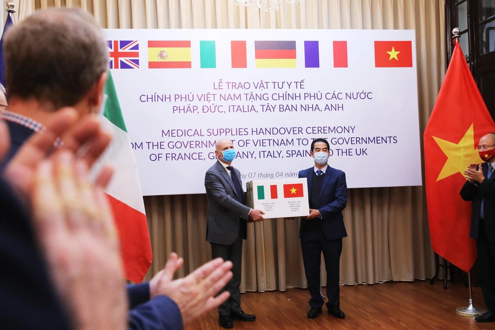 Thừa uỷ quyền của Thủ tướng Chính phủ, Thứ trưởng Bộ Ngoại giao Tô Anh Dũng trao hàng hỗ trợ của Việt Nam đến Đại sứ Italy tại Việt Nam Antonio Alessandro. (Ảnh: Lâm Khánh – TTXVN)