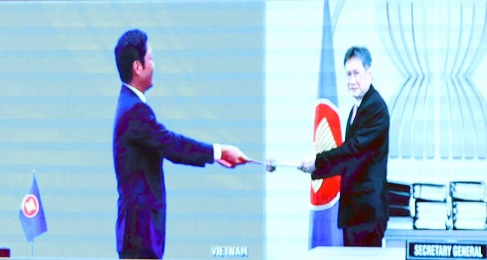 Ông Trần Tuấn Anh, Bộ trưởng Bộ Công Thương Việt Nam tiến hành trao tượng trưng bản lưu chiểu Hiệp định Đối tác Kinh tế Toàn diện Khu vực RCEP tới Ngài Lim Jock Hoi, Tổng Thư ký ASEAN. (Ảnh: Thống Nhất/TTXVN)