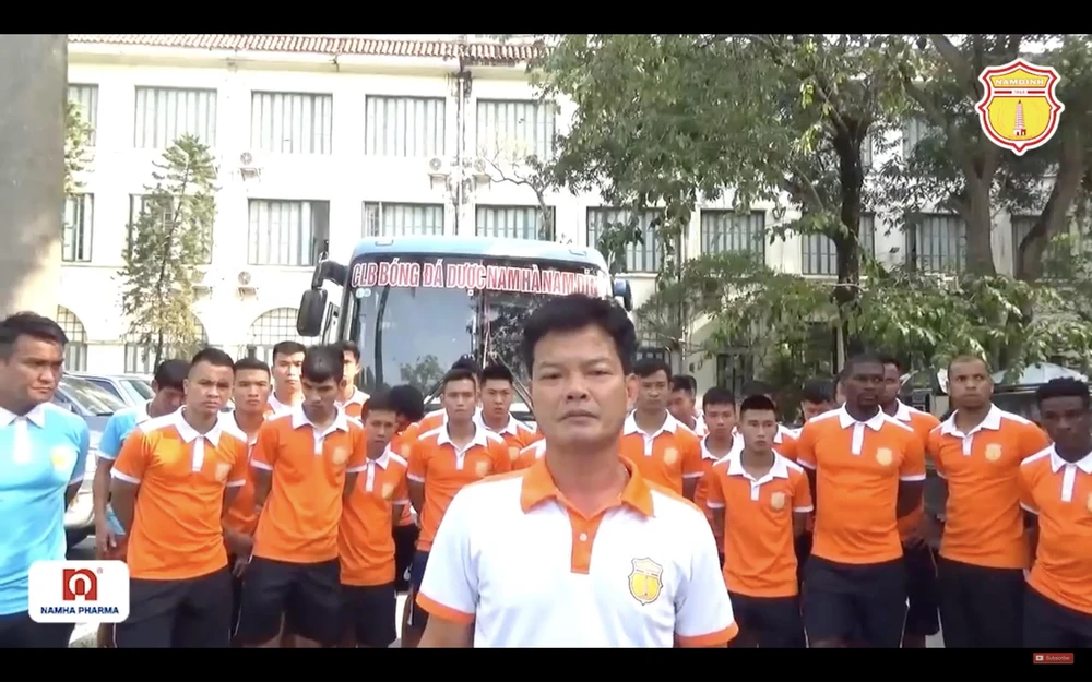 Giám đốc kỹ thuật Nguyễn Văn Sỹ cùng cầu thủ câu lạc bộ Nam Định cúi đầu xin lỗi các cổ động viên bị ảnh hưởng bởi sự cố pháo sáng. (Ảnh chụp màn hình)