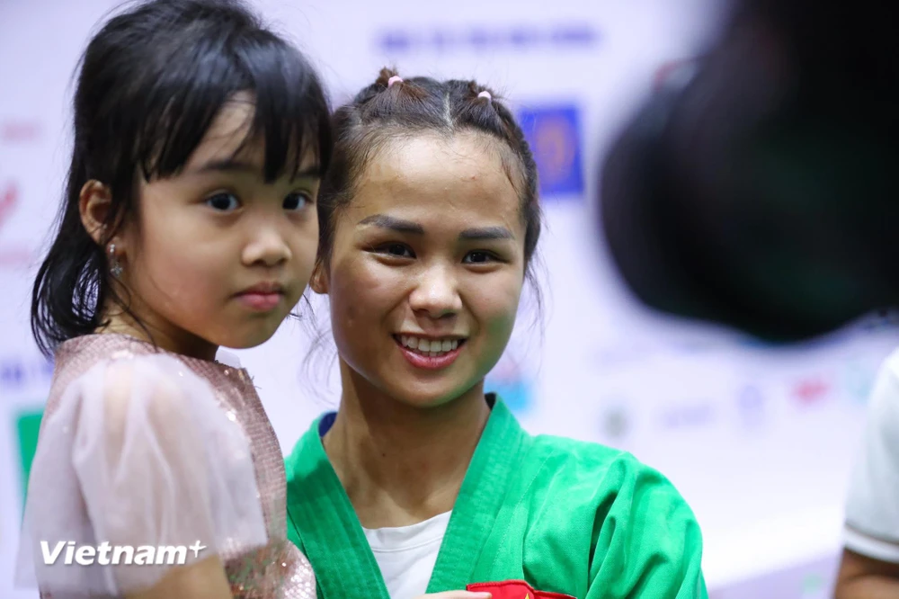 Vận động viên Tô Thị Trang hạnh phúc bên gia đình sau khi giành huy chương vàng. (Ảnh: PV/Vietnam+) 