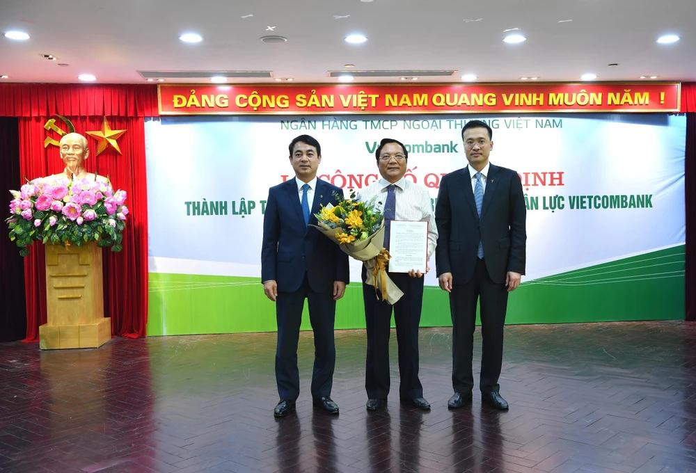 Lãnh đạo Vietcombank trao quyết định và tặng hoa cho ông Kiều Hữu Thiện, tân Giám đốc Trường Đào tạo Vietcombank. (Ảnh: CTV/Vietnam+)