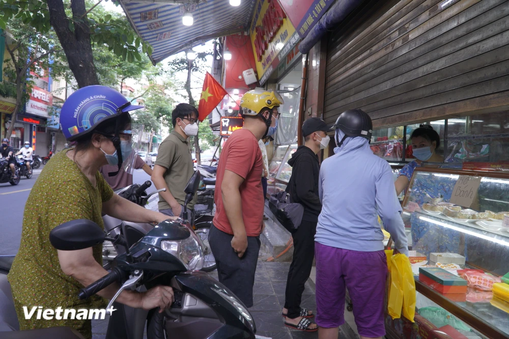 Dòng người xếp hàng mua san sát, không thực hiện giãn cách tối thiểu 2m. (Ảnh: Minh Hiếu/Vietnam+)