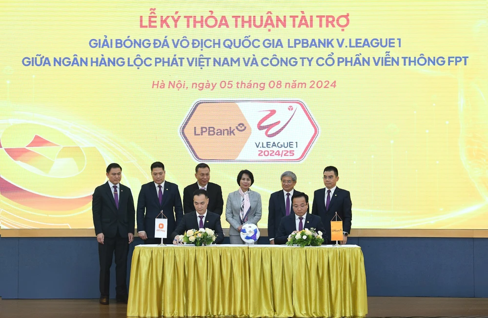 Đại diện LPBank, ông Hoàng Văn Phúc – Phó Tổng Giám đốc và đại diện FPT Telecom, ông Nguyễn Hoàng Linh – Tổng Giám đốc thực hiện ký kết dưới sự chứng kiến của đại diện Lãnh đạo Cục Thể dục Thể thao, Liên đoàn Bóng đá Việt Nam, LPBank, FPT và VPF. (Ảnh: Vietnam+)