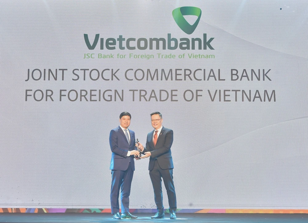 Ông Hồng Quang - Thành viên Hội đồng quản trị kiêm Giám đốc Khối Nhân sự đại diện Vietcombank nhận cúp vàng "Harmonia" từ Ban tổ chức. (Ảnh: Vietnam+)