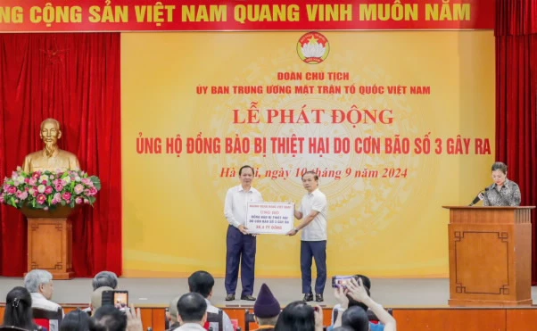 Phó Thống đốc Thường trực Đào Minh Tú trao ủng hộ của ngành Ngân hàng. (Ảnh: Vietnam+)